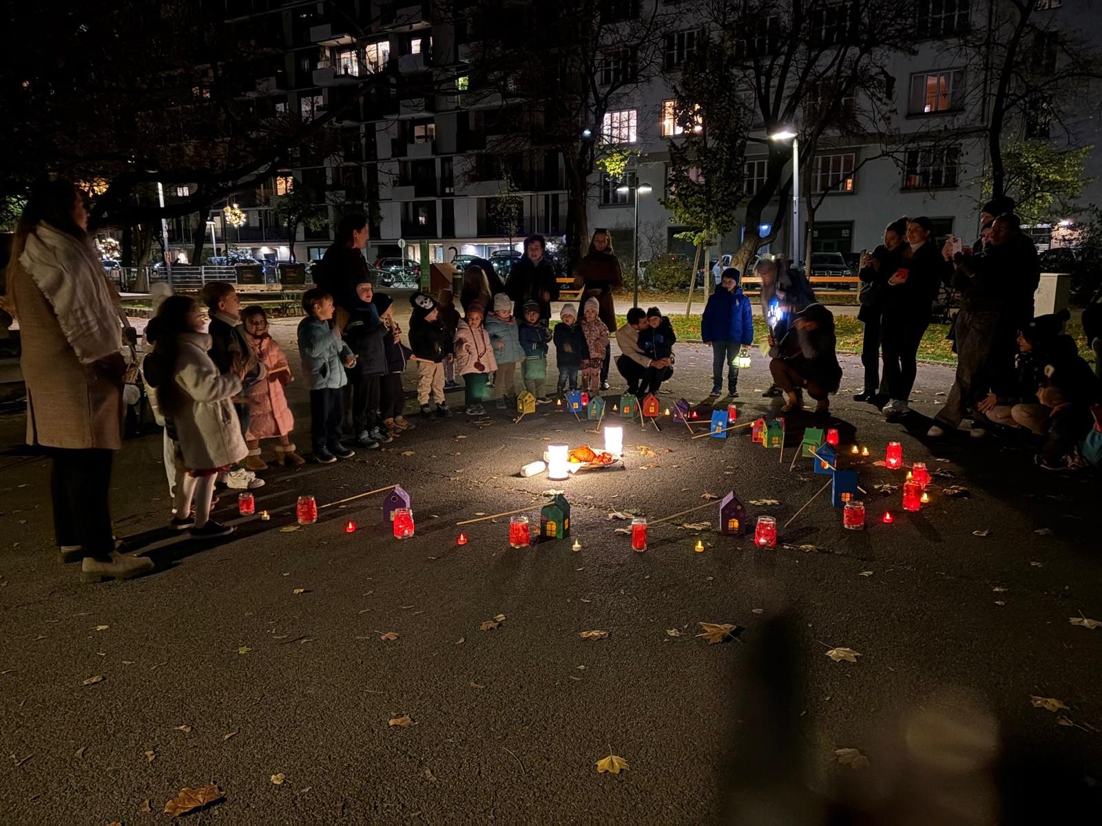 Children and adults gathered around colourful lanterns in the evening