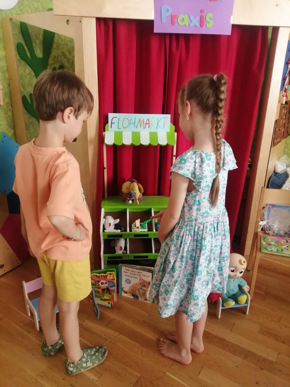Two children playing together at a small market stall